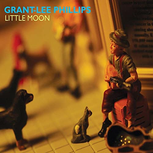 Miniature figurine of a man with a guitar and two dog statues.