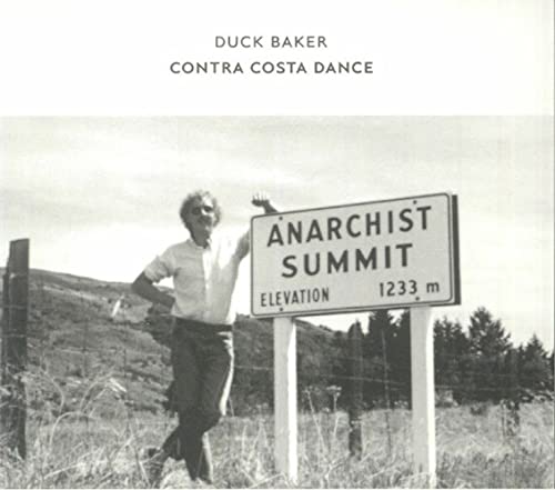 Black and white photo of a man posing by a sign reading "Anarchist Summit".