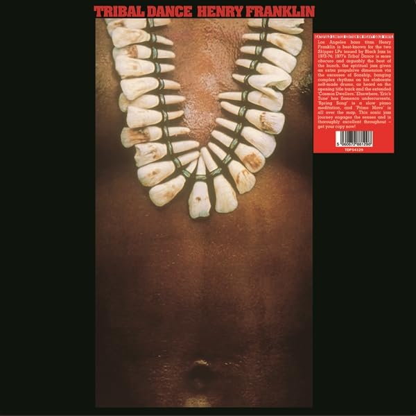 Gold vinyl record cover featuring a tooth necklace on a red background.