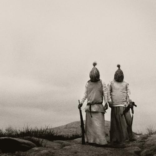 Two figures with rifles stand on a hill, viewed from behind.