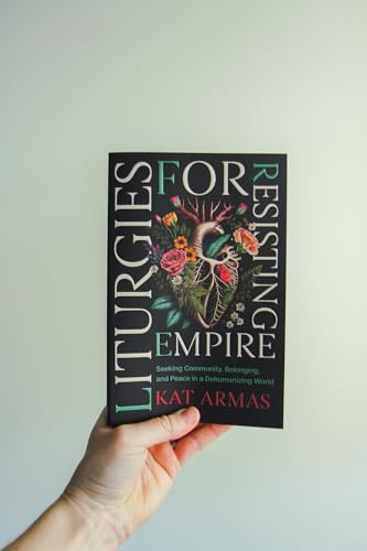 Book cover with floral heart illustration held in a hand.