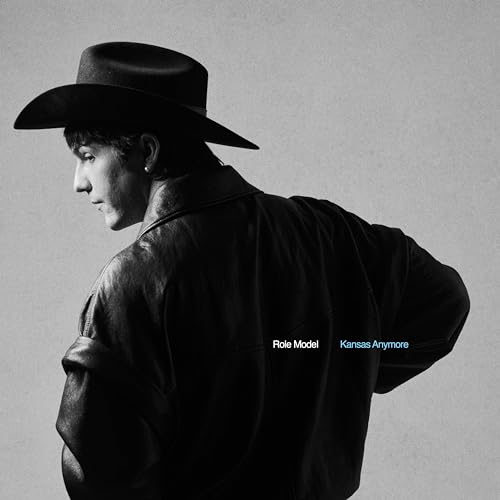 Black and white portrait of a person in a hat and leather jacket.