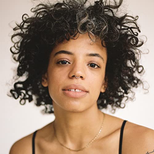 Close-up portrait of Tasha, a woman with curly dark hair and a nose ring.