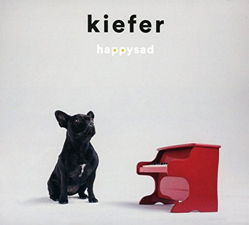 CD cover: black dog sitting beside a small red piano.