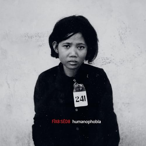 Black and white portrait of a young person wearing a numbered tag.