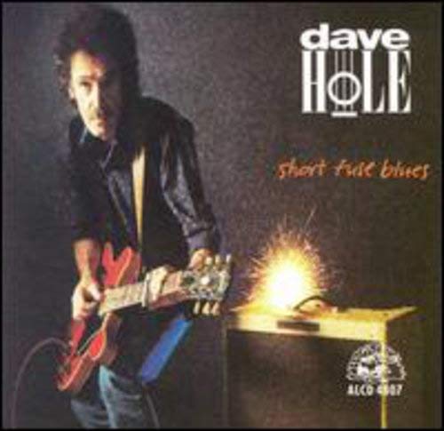 CD cover: musician with red guitar, exploding amplifier, dark background.