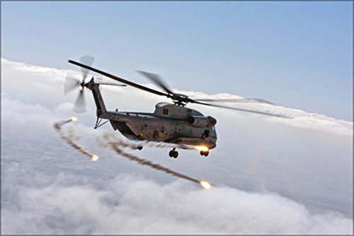 Military helicopter firing flares above clouds, side view.
