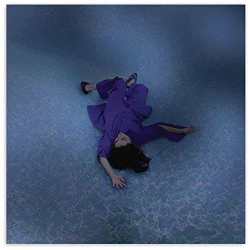 Person in purple clothing lying on a textured blue surface.