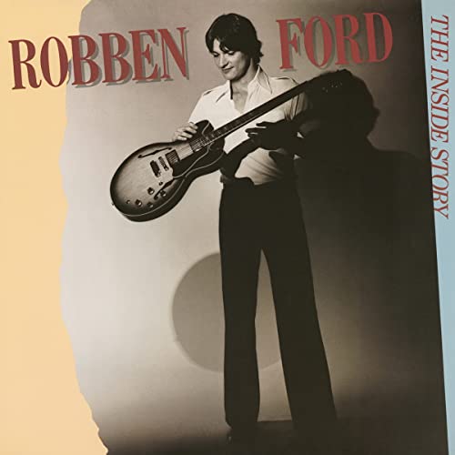 Robben Ford holding a guitar on album cover, warm tones.