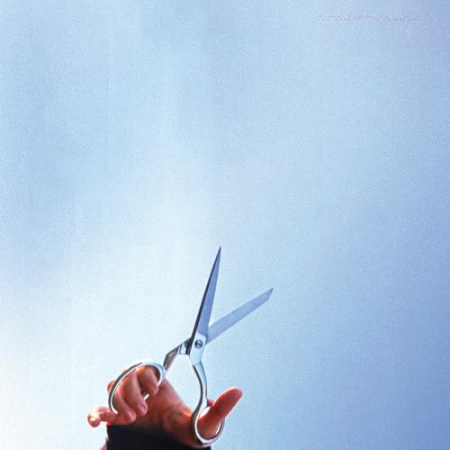 Hand holding open silver scissors against a bright blue sky.