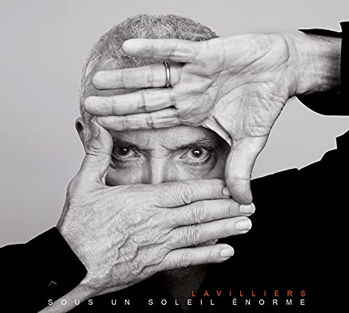 Black and white portrait of Bernard Lavilliers framed by his own hands.