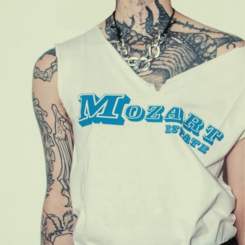 Man with tattoos wearing a white shirt with "Mozart Estate" logo.
