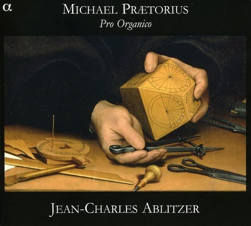 CD cover: hands holding a geometric cube with organ-building tools.