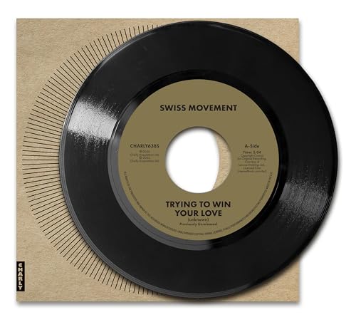 Black vinyl record with a yellow label, resting on a brown card sleeve.