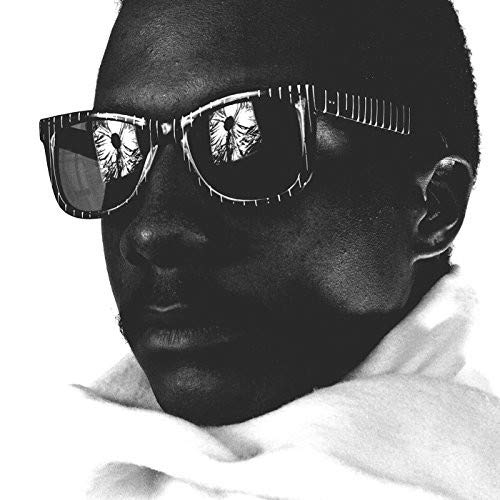 Black and white portrait of a person wearing large, patterned sunglasses.