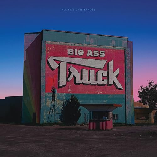 Red barn wall with painted text "Big Ass Truck" and twilight sky.
