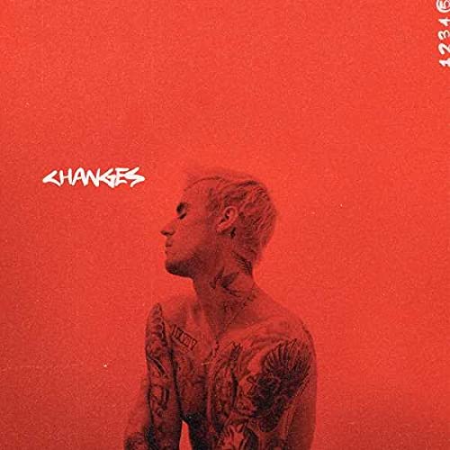 Justin Bieber shirtless with tattoos against a solid red background with Changes text.