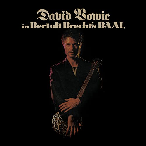 David Bowie as Baal, holding a guitar, on a dark album cover.