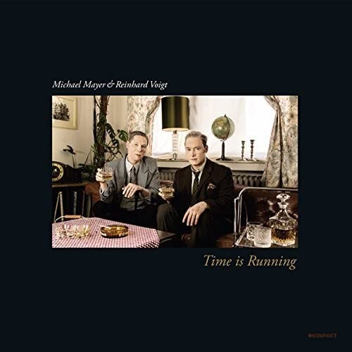 Two men with drinks seated in a vintage-style room, album cover.