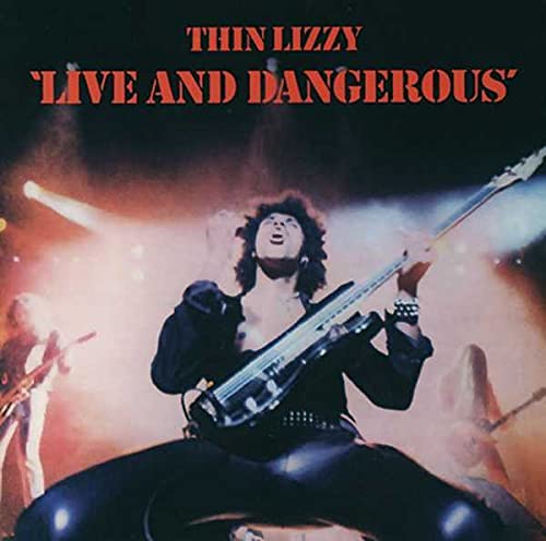 Thin Lizzy performing live on stage under bright spotlights for the Live and Dangerous album.