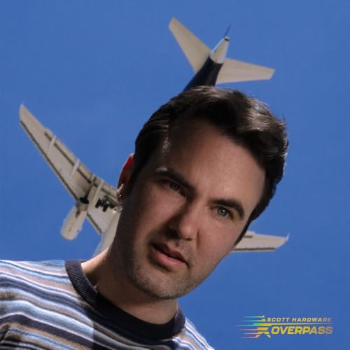 Man with short hair, looking up at a small airplane in a blue sky.