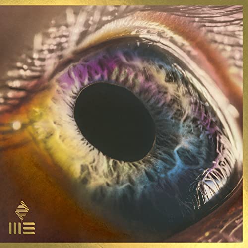 Close-up of a colorful human eye, with gold geometric shapes.