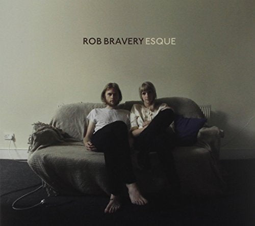 CD cover: two people sitting on a grey sofa indoors.