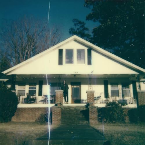 Vinyl album cover featuring a faded image of a house and figure.