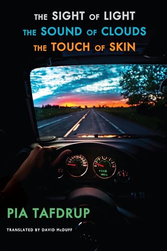 View from inside a car looking out at a sunset road over the dashboard.