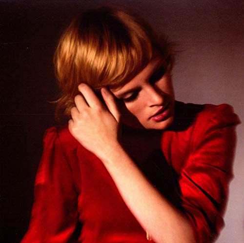 Close-up of a young woman with red hair and a red shirt.