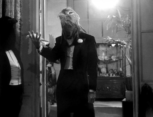Black and white still from "Judex" featuring a figure with a bird-like mask.