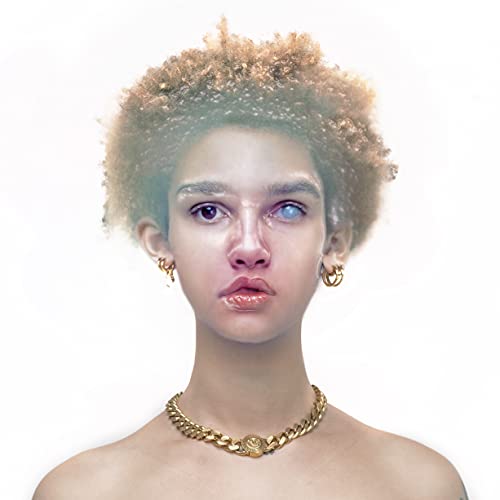 Close-up portrait of a young woman with curly hair and gold jewelry.
