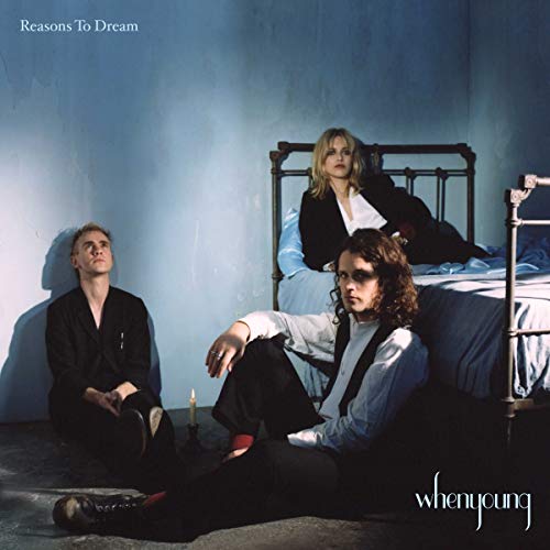 Album cover: three people in dark clothing near a bed.