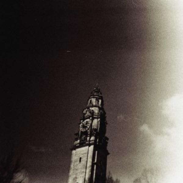 Low-angle, grainy black and white photo of a tall clock tower.