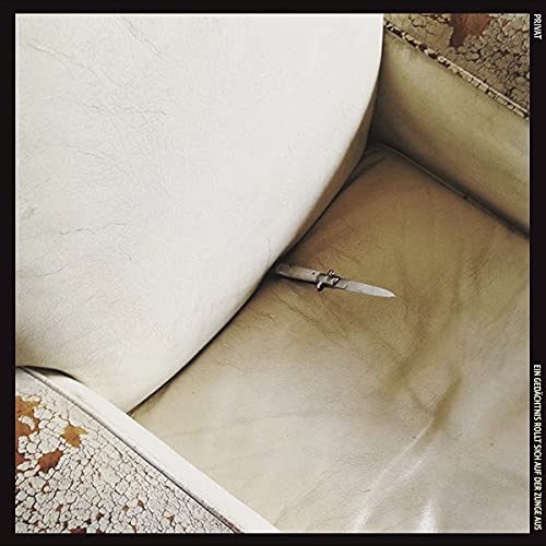 Vinyl album cover: a knife rests on a worn, beige leather couch.