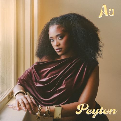 Album cover featuring a woman with curly hair, gold text, and warm tones.