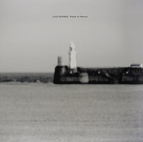 Black and white album cover with a seascape and distant structure.