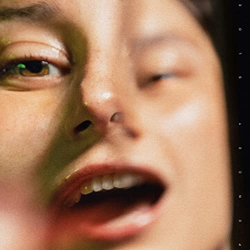 Close-up of a person’s face with dramatic lighting, CD cover art.