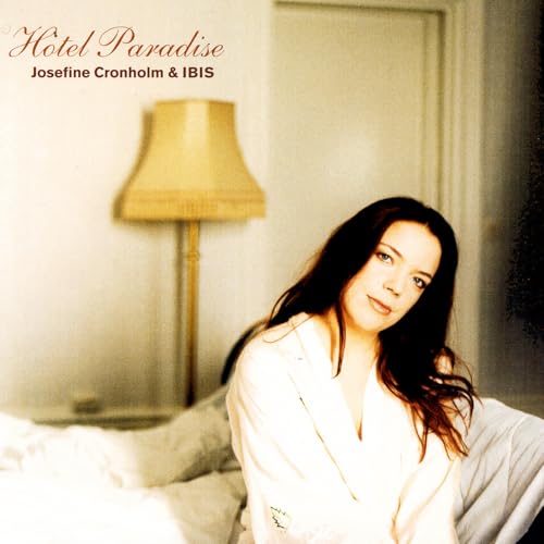 CD cover: woman with long hair near a lamp and bed.