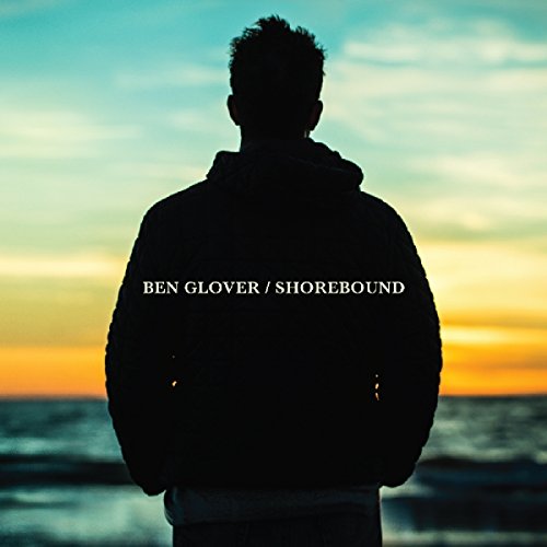 Silhouette of a man facing the ocean at sunset, album cover.