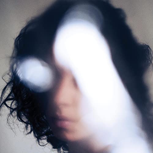 Blurred portrait of a person with white covering most of their face.