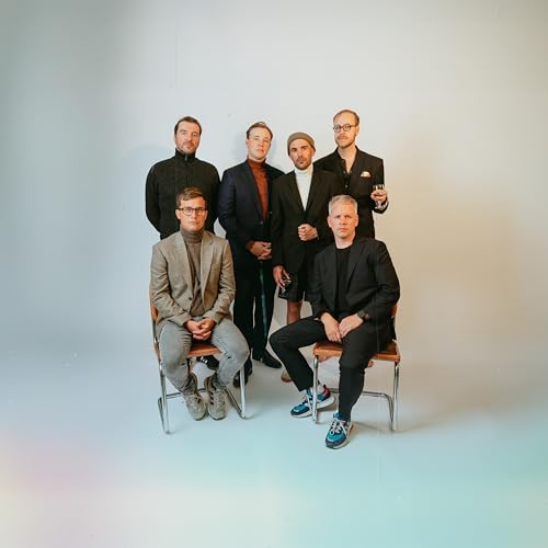 Six men in formal wear pose for a studio portrait.