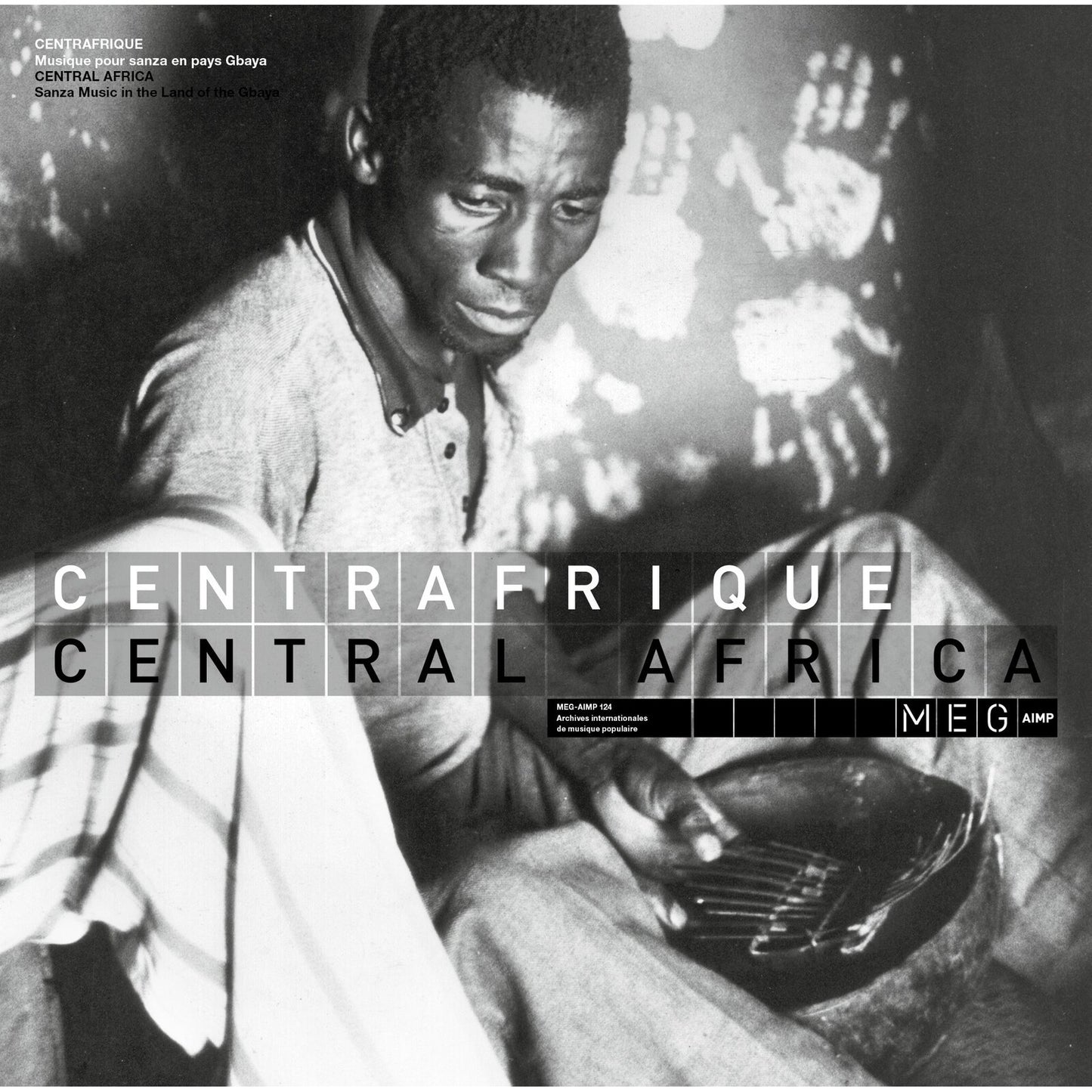 Black and white photo of a man playing a sanza instrument in Central Africa.