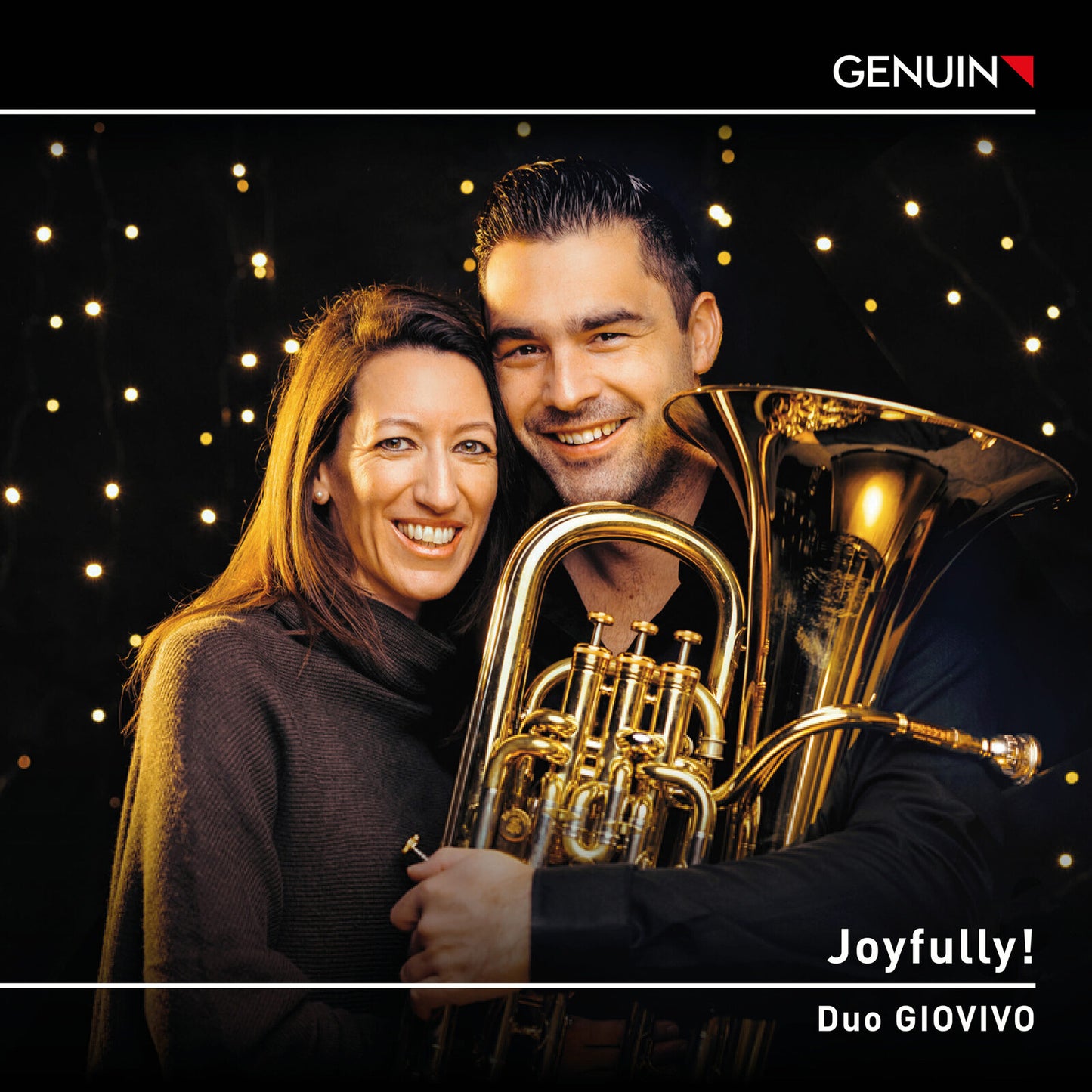 Couple with a French horn against a blurred, sparkling background.
