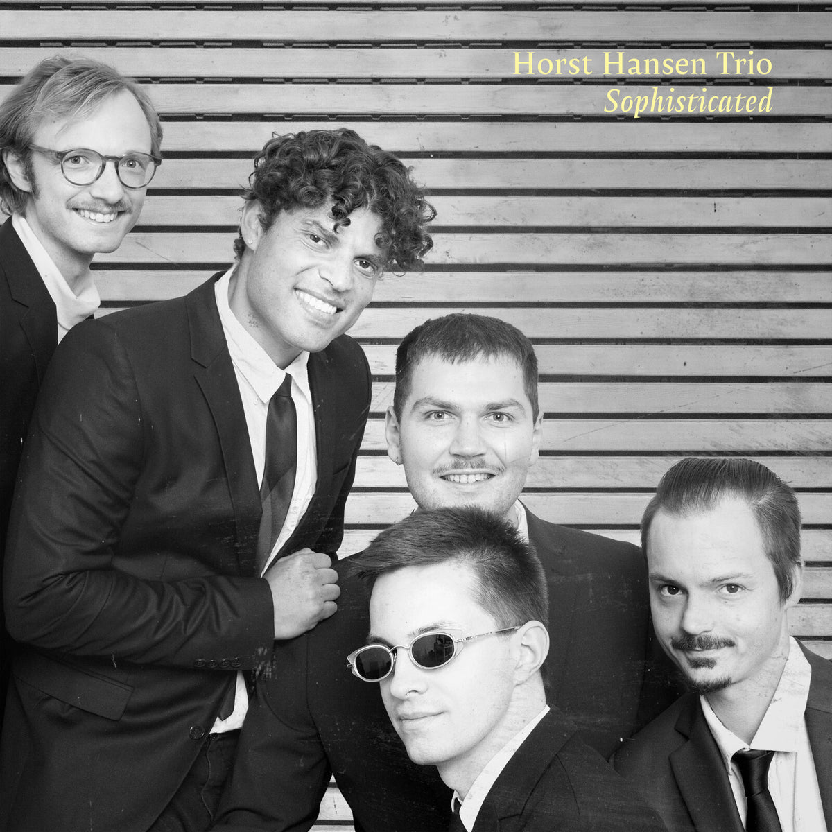 Black and white photo of five men in suits, album cover.