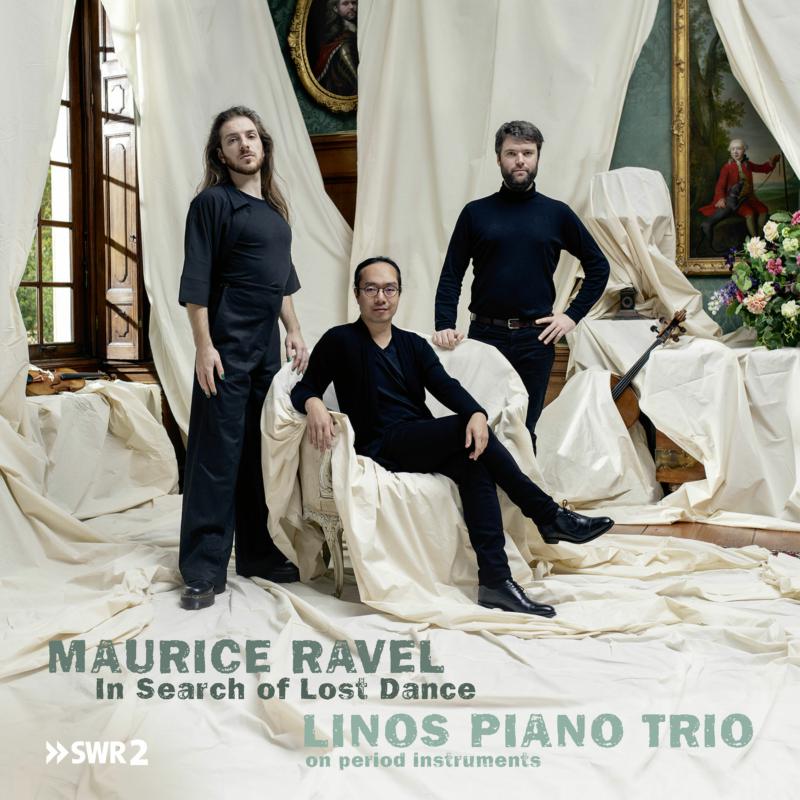 Three musicians in formal wear pose in a classical interior.