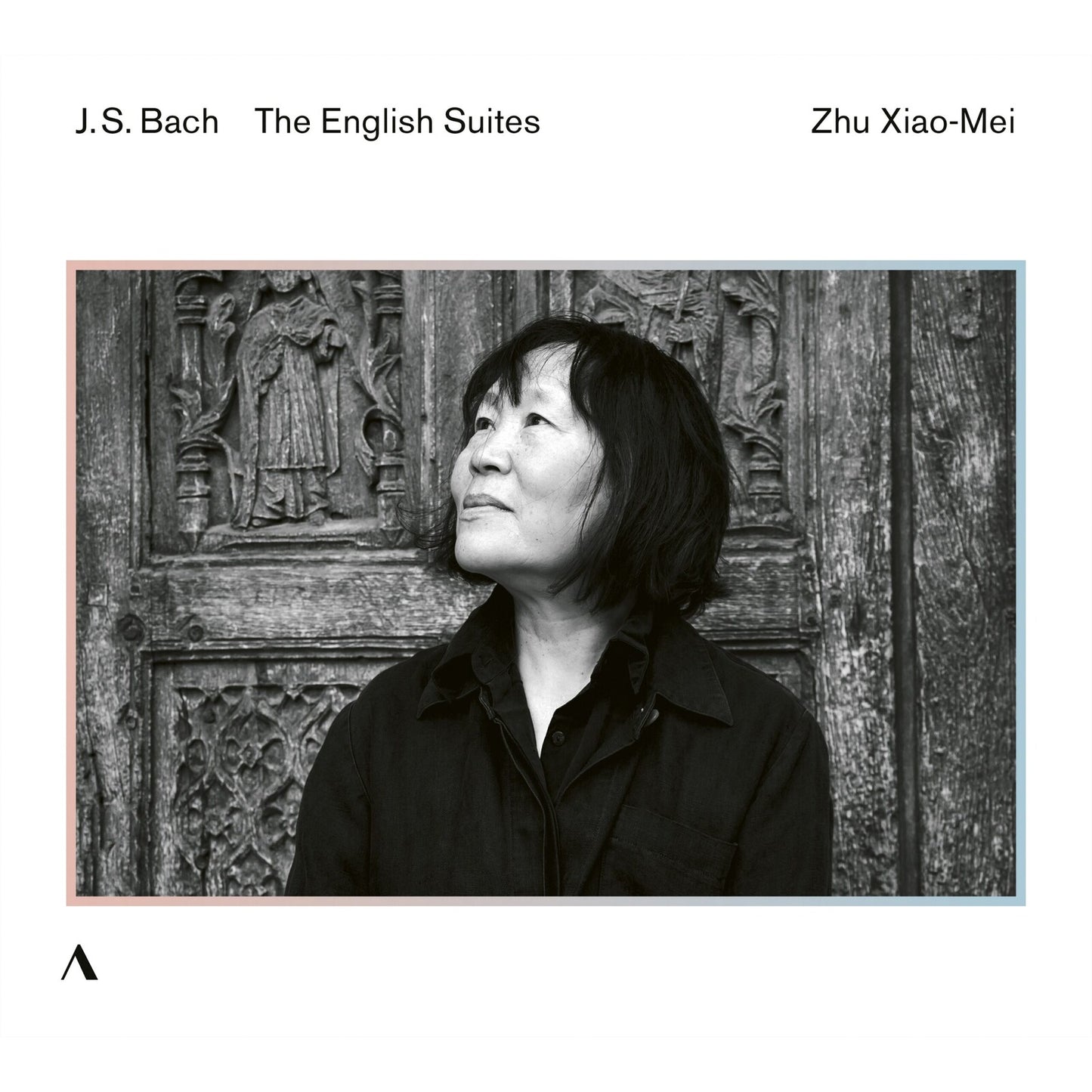 Black and white portrait of Zhu Xiao-mei, classical musician, against a carved door.