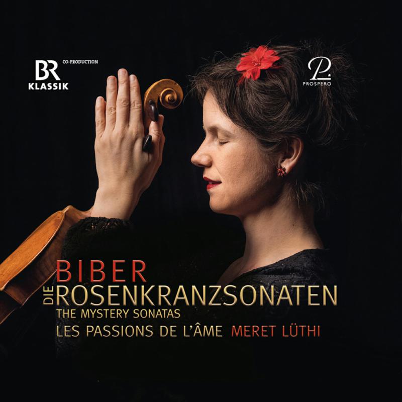 Meret Lüthi holding a violin scroll against her hands with eyes closed, black background.