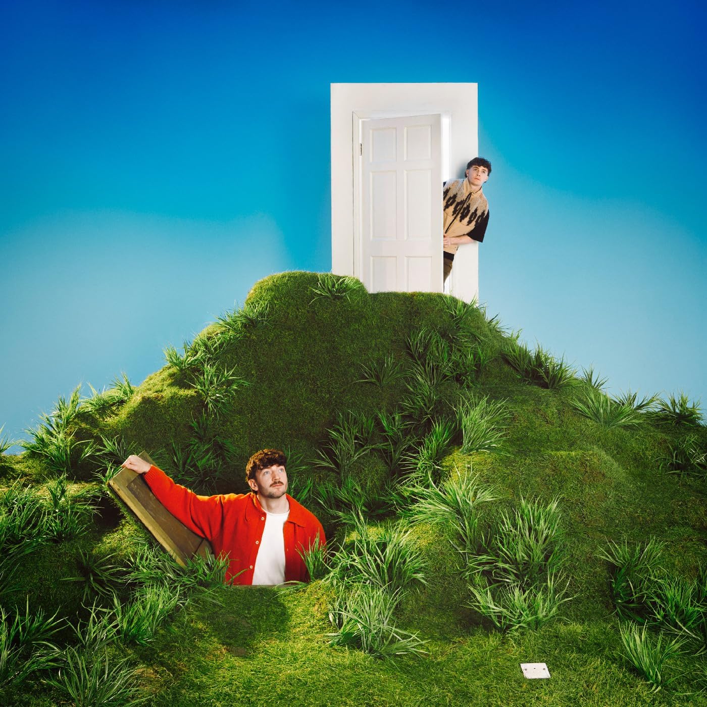 Album cover: two men and a door on a grassy hill, blue sky.