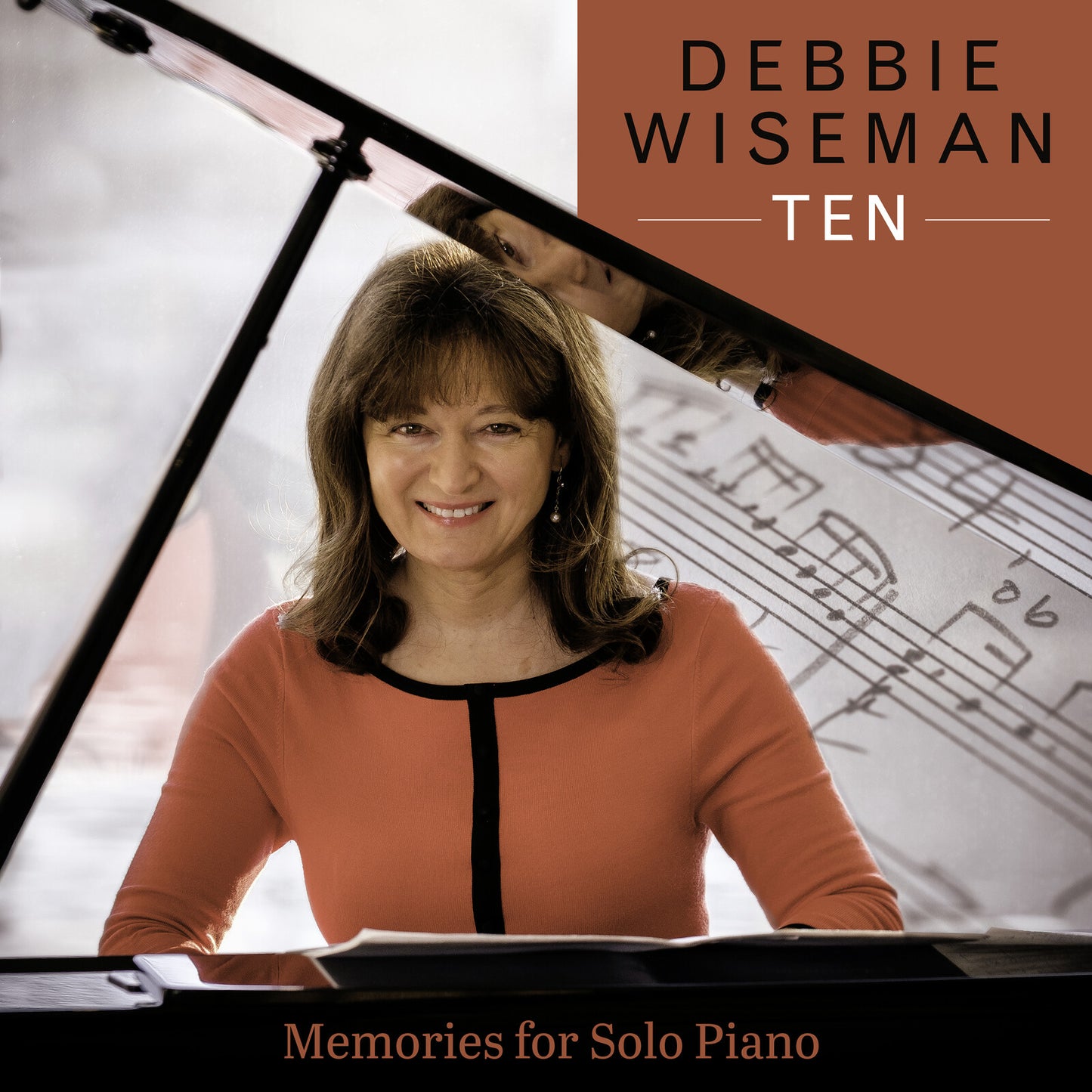 Debbie Wiseman at a piano with sheet music, album cover art.